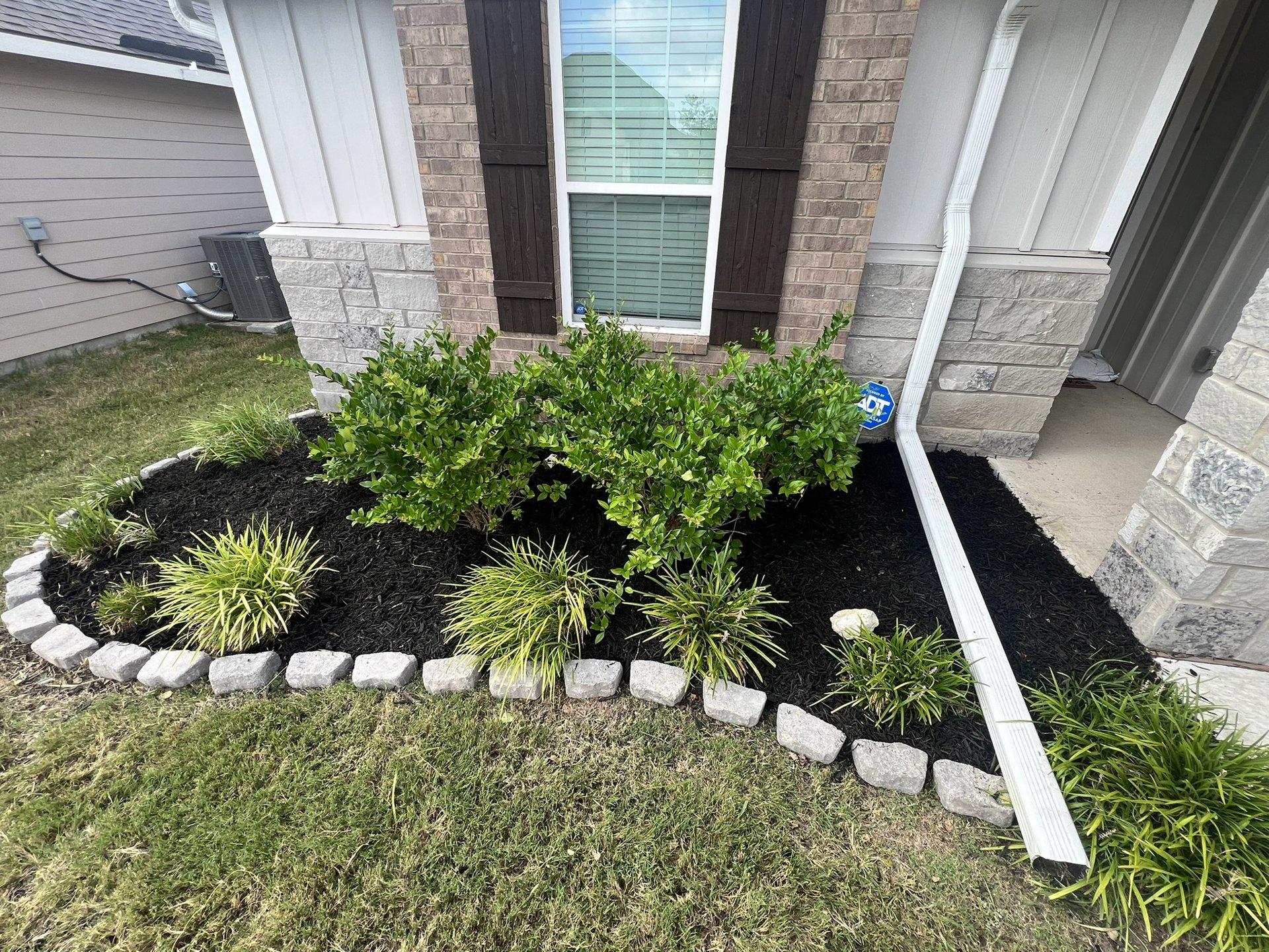 Front entry flowerbed with mulch and paver edging